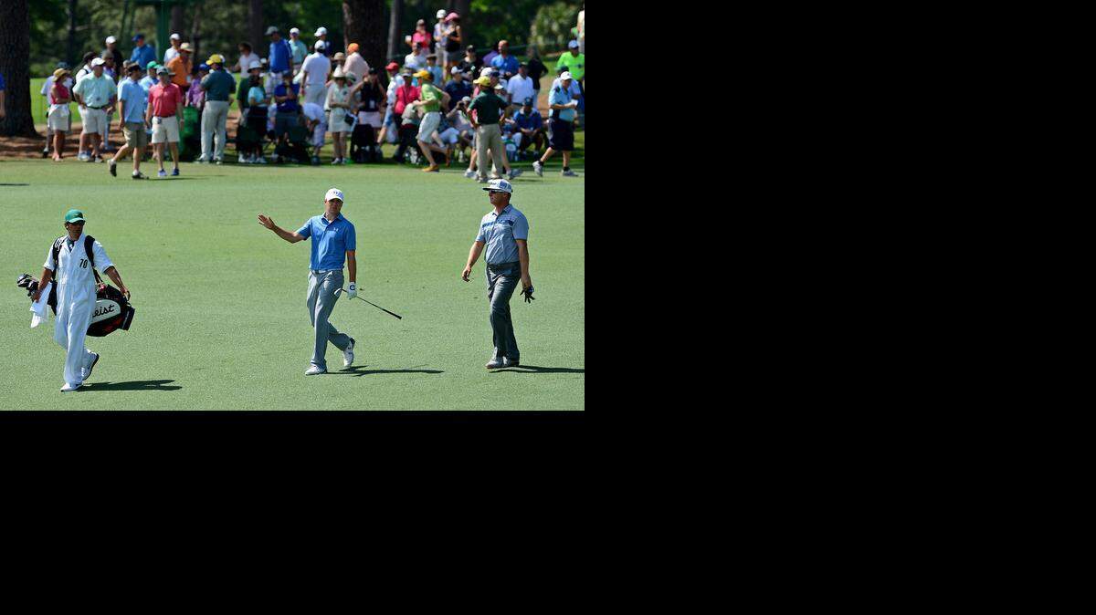 
Jordan Spieth, center, talks to golfer Charley Hoffman, right, as caddie, Brett Waldman, left, looks on as they walk the second fairway during third round action of the Masters on Saturday, April 11, 2015 at Augusta National Golf Club.
