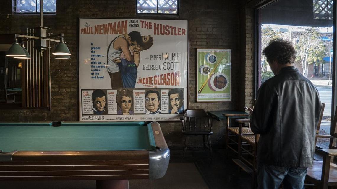 Tom Sorensen takes note in front of his favorite poster at recently closed Dilworth Billiards. Tom is retiring Friday, but not before he looks back on his nearly 35 years at The Observer.