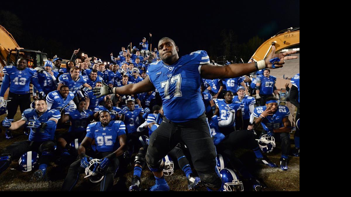
Duke guard Laken Tomlinson (77) photo bombs a group shot as the Blue Devil football team poses with heavy equipment prior to the groundbreaking ceremony after Duke beat Wake Forest 41-21 at Wallace Wade Stadium, Nov. 29, 2014 in Durham. Tomlinson likely represents the Triangle’s best chance at having a first-round pick in the 2015 NFL draft.
