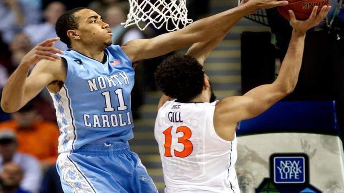 
Virginia’s Anthony Gill has trouble getting past North Carolina’s Brice Johnson during the second half of Friday’s semifinal of the ACC tournament in Greensboro. The Tar Heels won 71-67 and will play in Saturday night’s championship game.
