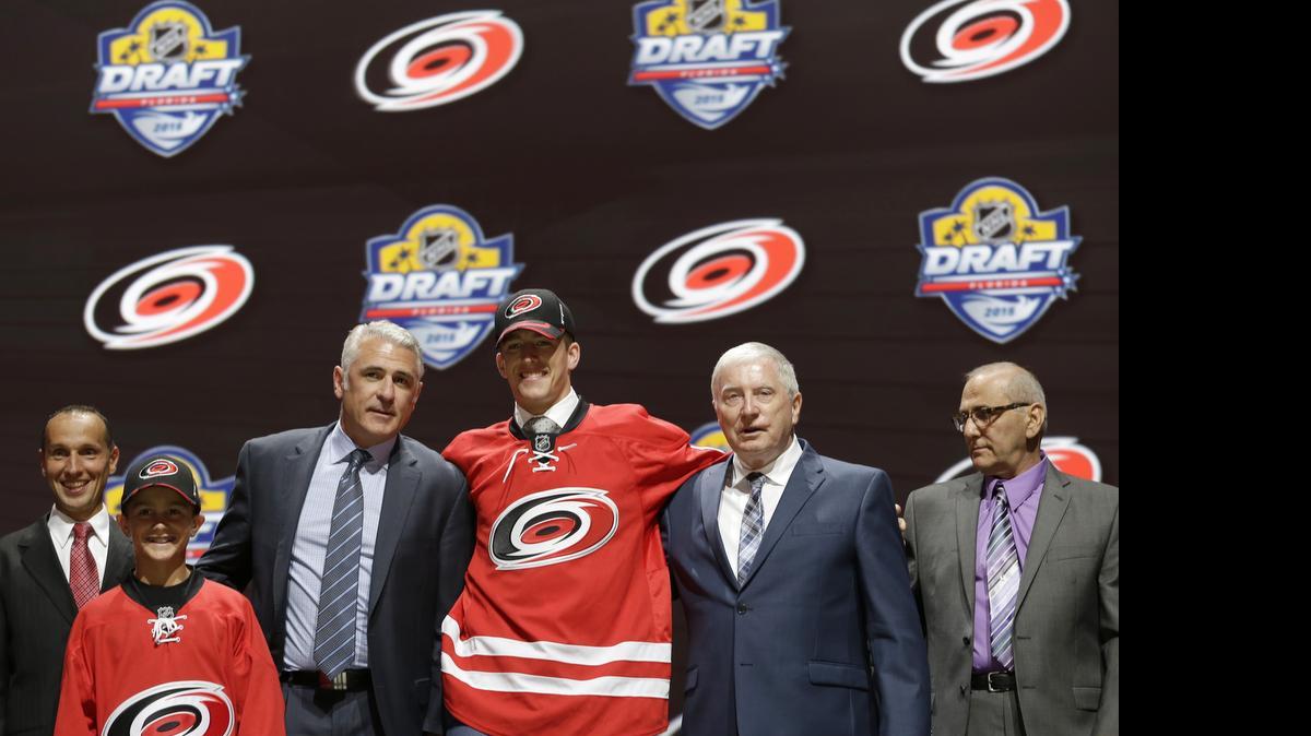 
Noah Hanifin, center, poses with team executives after being chosen fifth overall by the Carolina Hurricanes in the first round of the NHL Draft on Friday, June 26, 2015 in Sunrise, Fla. 
