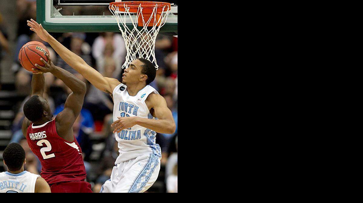 
UNC’s Brice Johnson blocks a shot by Arkansas’ Alandise Harris Saturday night in Jacksonville, Fla.
