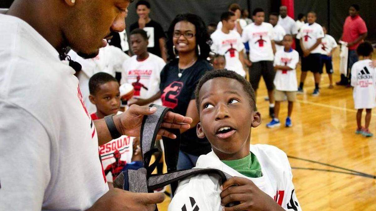 Ten-year-old Josef Brown of Garner, N.C. meets John Wall of the NBA’s Washington Wizards during the second annual John Wall Back 2 School Squad backpack give away on Friday, August 14, 2015 at the J.D. Lewis Multipurpose Center in Raleigh, N.C. Children in attendance received t-shirts, backpacks, water bottles, and were entered into a raffle for autographed basketballs and shoes. Wall said he was happy to be back in his hometown, and wanted to help the children be ready to return to school. 

