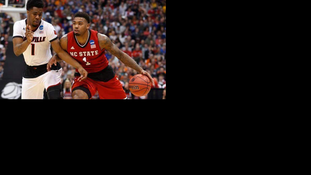 
N.C. State's Trevor Lacey tries to drive around Louisville's Anton Gill during the Wolfpack's game against Louisville in the semifinals of the NCAA East Region at the Carrier Dome in Syracuse.

