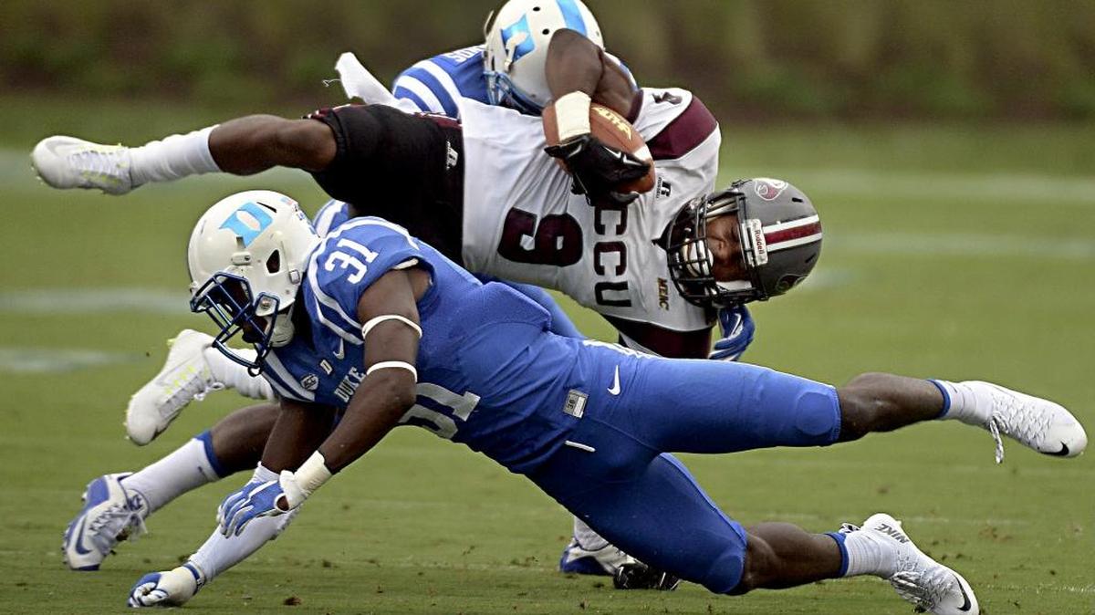 Duke cornerback Breon Borders (31) and Duke safety DeVon Edwards (27) upend NCCU's Jalen Wilkes (9).