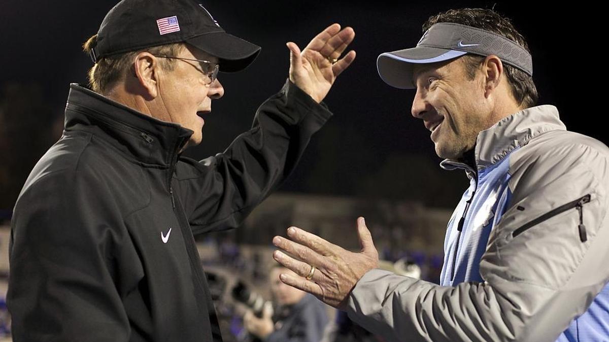 
UNC coach Larry Fedora talks with Duke coach David Cutcliffe prior to the Tar Heels' 2014 game against the Blue Devils at Wallace Wade Stadium in Durham.
