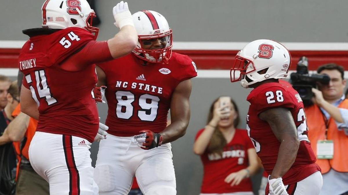 
N.C. State's Joe Thuney (54) and Benson Browne (89) celebrate with Jaylen Samuels (28) after Samuels scored on a three-yard touchdown against Troy at Carter-Finley Stadium in Raleigh.
