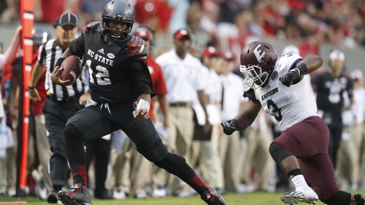 
N.C. State quarterback Jacoby Brissett (12) scrambles for yards as Eastern Kentucky linebacker Thomas Owens (3) closes in during the first half of the Wolfpack's game against Eastern Kentucky. N.C. State coach Dave Doeren asked baseball coach Elliott Avent to work with Brissett on his sliding technique during spring practice. 
