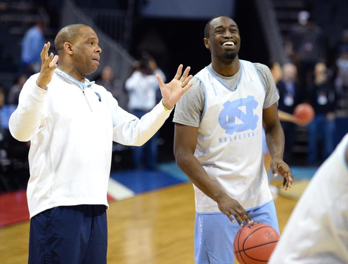 North Carolina Tar Heels assistant coach Hubert Davis, left, jokes with Theo Pinson Thursday in Charlotte. Pinson leads the Tar Heels in assists this season and is second on the team in rebounding.