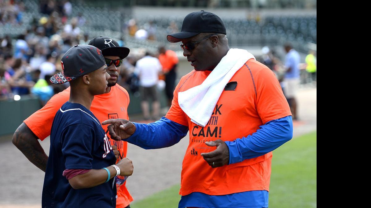 
Former NFL and MLB star Bo Jackson, right, talks with Baltimore Ravens wide receiver Steve Smith Sr., center, and his son, Peyton Smith, left, during the Kick It With Cam! celebrity kickball games at BB&T BallPark in Charlotte, Friday, June 12, 2015.
