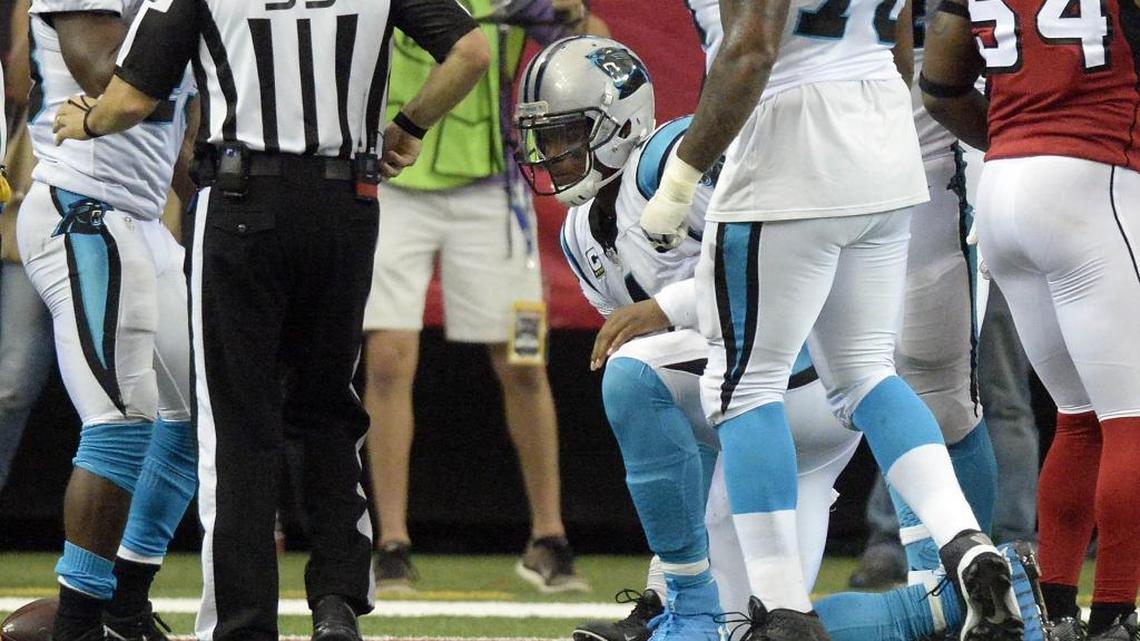 Carolina Panthers quarterback Cam Newton (1) climbs to one knee after he was hit by Atlanta Falcons outside linebacker Deion Jones during a 2-point conversion on Sunday. Newton sustained a concussion on the play.