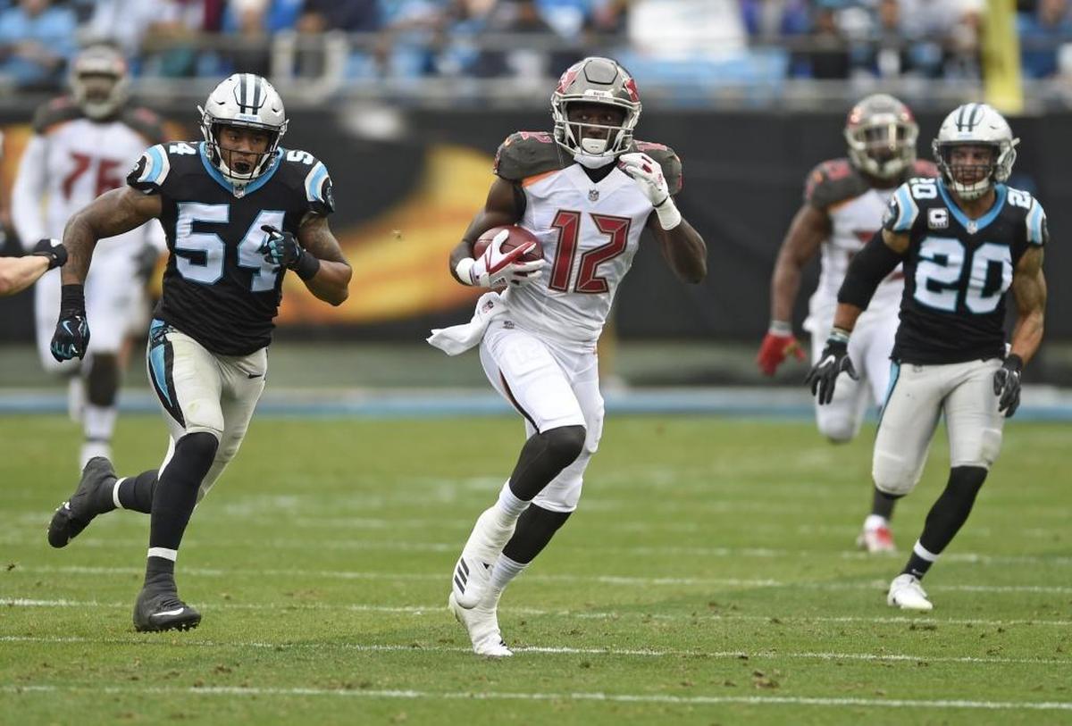 Tampa Bay’s Chris Godwin (12) broke a couple of tackles on this 70-yard play Sunday. Carolina’s Shaq Thompson (54) and Kurt Coleman (20) are in pursuit.