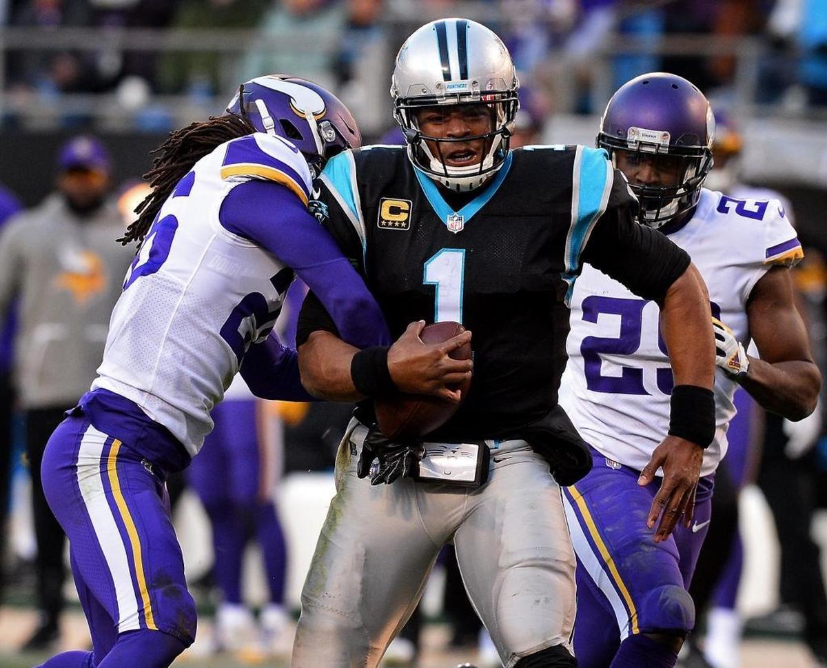 Carolina Panthers quarterback Cam Newton (1) holds onto the ball as Minnesota tries to strip it away at the end of his 62-yard run.