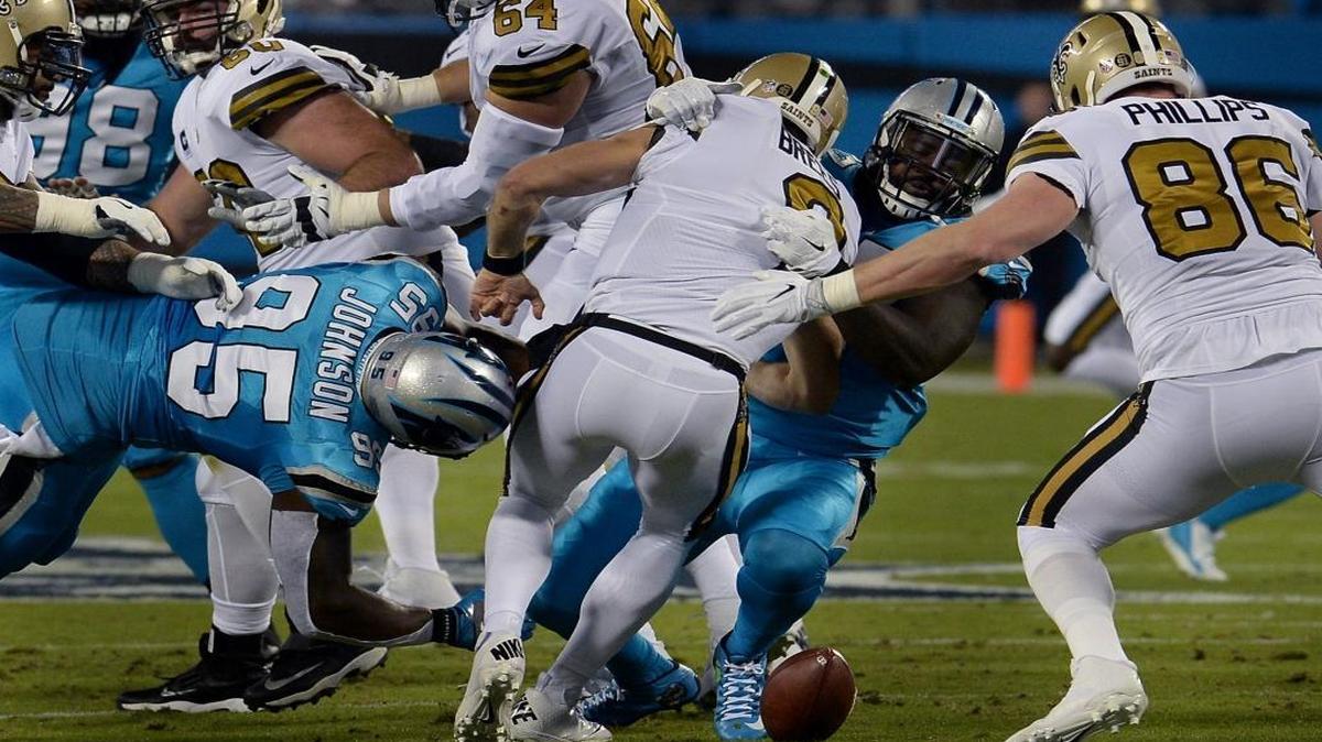 Carolina Panthers defensive ends Charles Johnson, left and Mario Addison work together to make a sack and strip the ball from New Orleans Saints quarterback Drew Brees during Thursday night’s game.