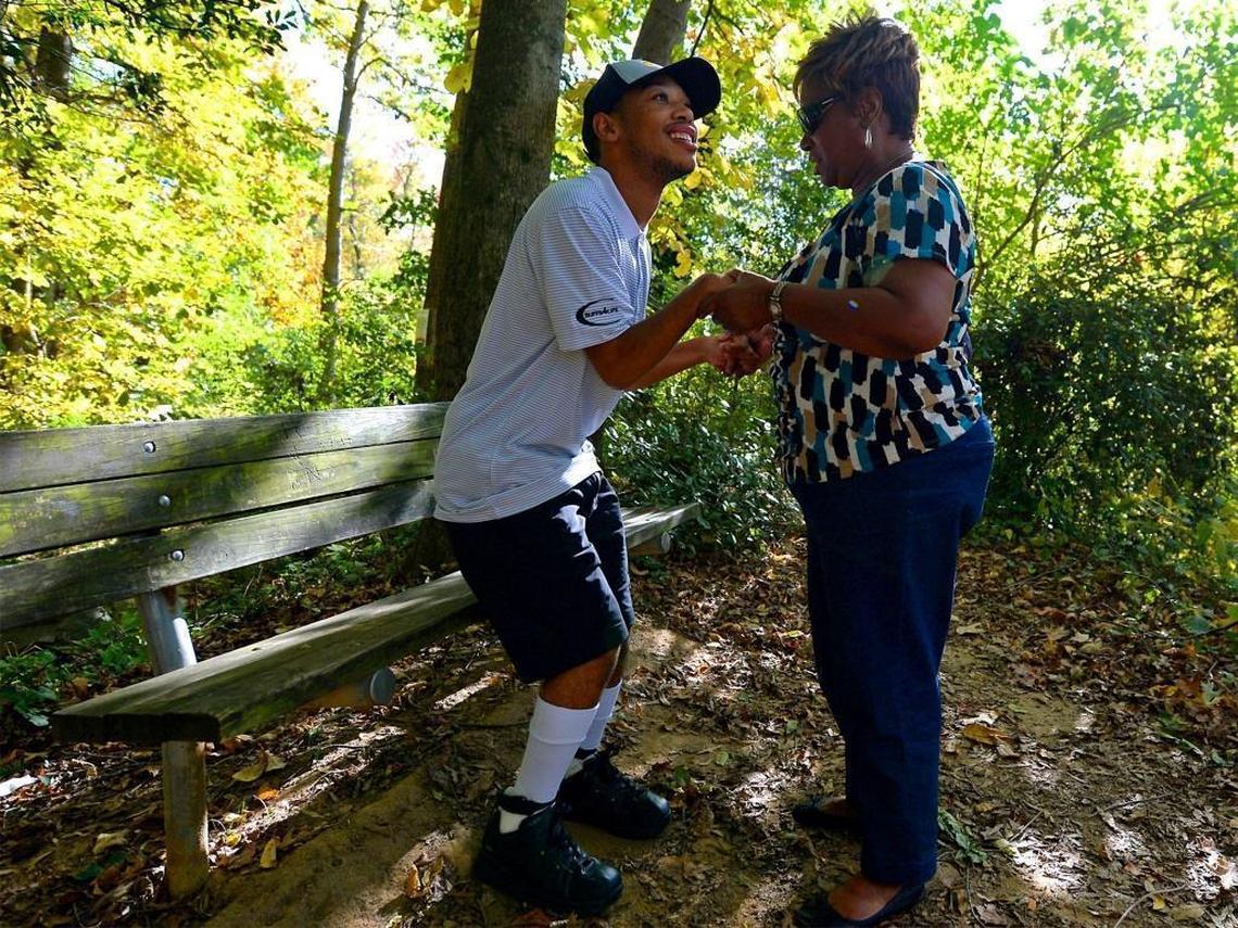 Chancellor Lee Adams, left, is helped to his feet by his grandmother, Saundra Adams, at a park in Charlotte. Doctors believed when he was born that Chancellor Lee, who suffers from cerebral palsy, would never walk. He now walks regularly, using a walker or steadying himself on Adams’ arm.
