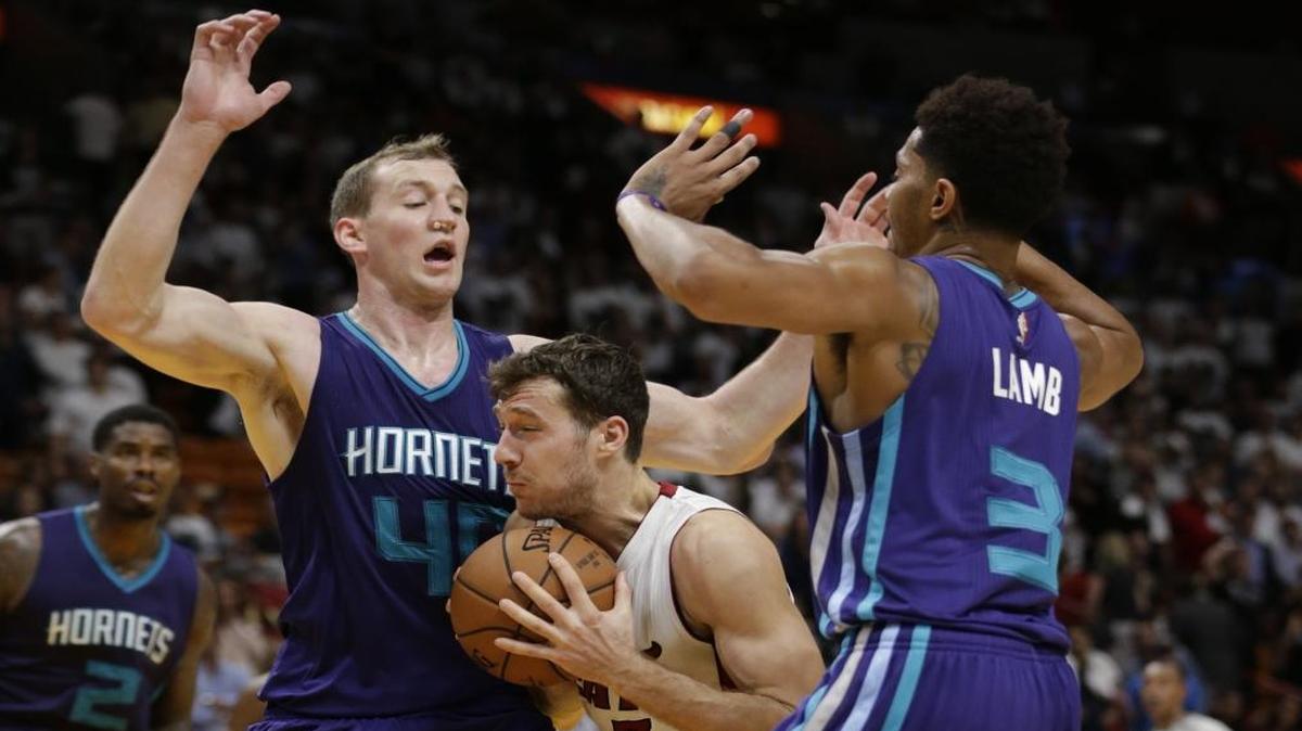 Miami Heat guard Goran Dragic (7) drives to the basket against Charlotte Hornets forward Cody Zeller (40) and guard Jeremy Lamb (3) on Friday in Miami. The Hornets defeated the Heat 97-91.
