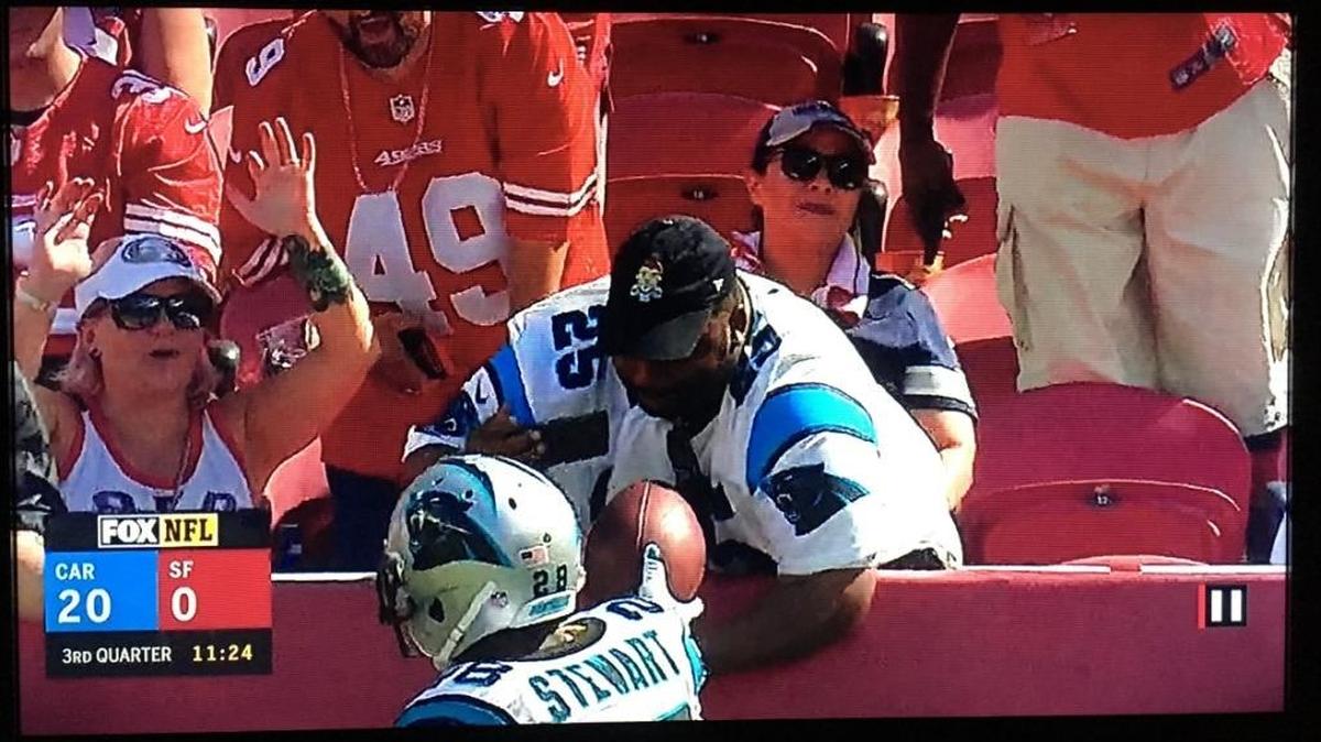 In this screenshot taken from the Carolina-San Francisco NFL Fox Sports telecast Sunday, Jonathan Stewart hands the football he just scored a touchdown with to Panthers fan Daniel Solomon.