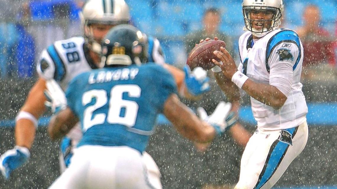 
With the rain falling hard during one of the soggiest games in Bank of America history, Carolina Panthers quarterback Cam Newton drops back to pass the ball as tight end Greg Olsen blocks the last time the Panthers played Jacksonville, in 2011. Olsen would eventually catch a 16-yard TD pass from Newton to win the game.
