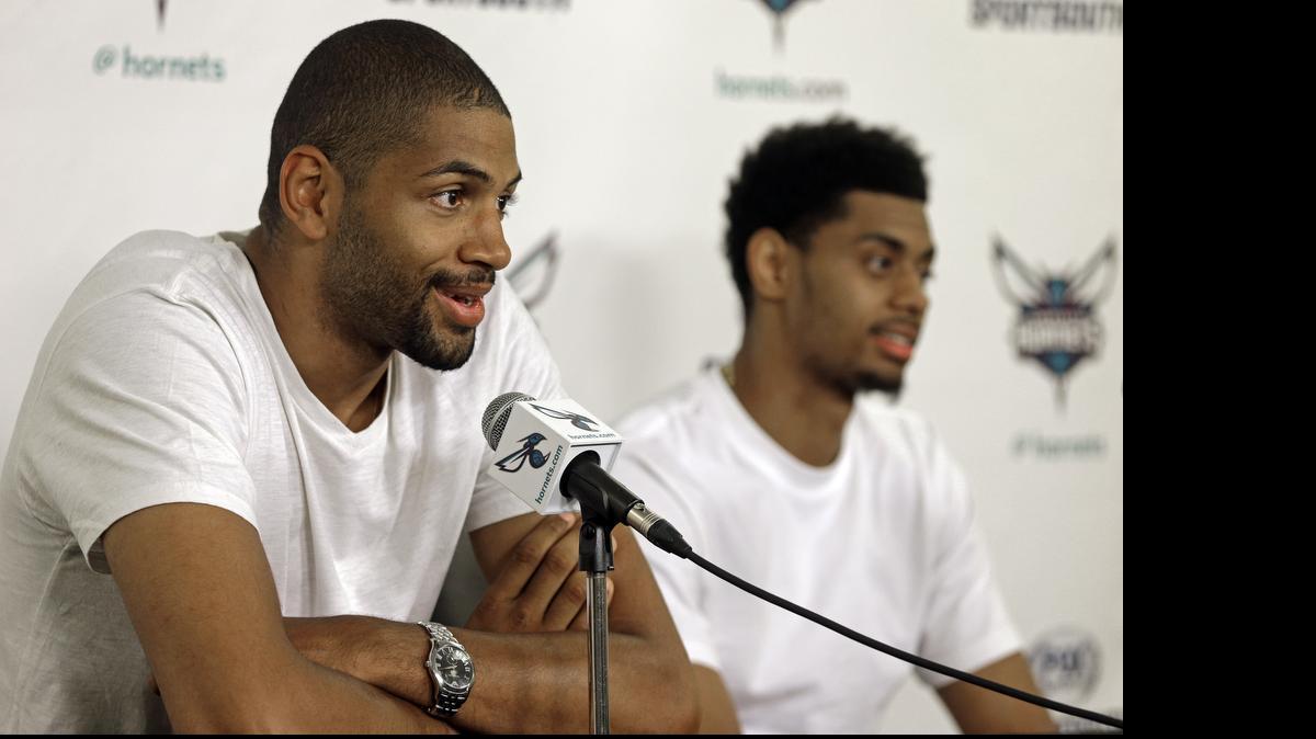 
The Charlotte Hornets’ Nicolas Batum (left) answers a question as Jeremy Lamb listens during a new conference in Charlotte in June. Batum is penciled in to start at shooting guard for the Hornets in 2015-16, according to coach Steve Clifford.
