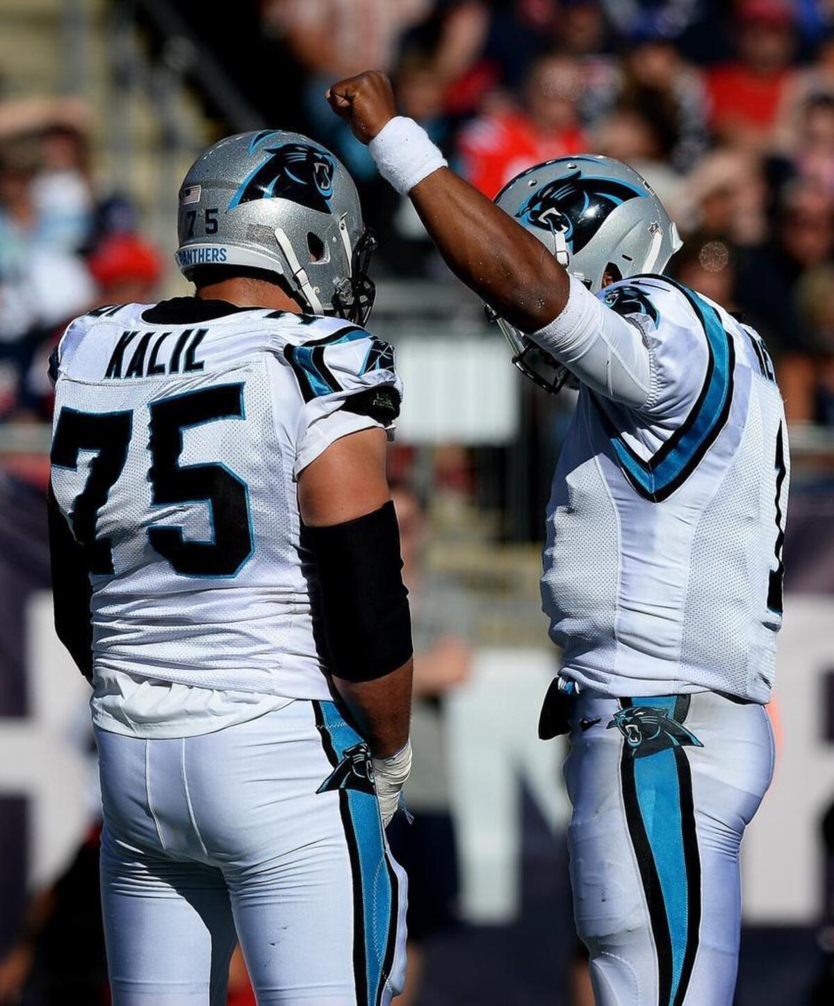Carolina Panthers quarterback Cam Newton celebrates a touchdown against New England Sunday with a clenched fist in what he said was a tribute to his “black pride.” The Panthers defeated the Patriots 33-30. Looking on at left is tackle Matt Kalil.