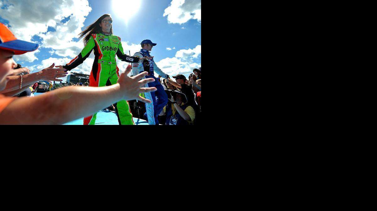 
NASCAR Sprint Cup Series driver Danica Patrick slaps hands with fans during driver introductions for the Daytona 500 at Daytona International Speedway in February 2015.
