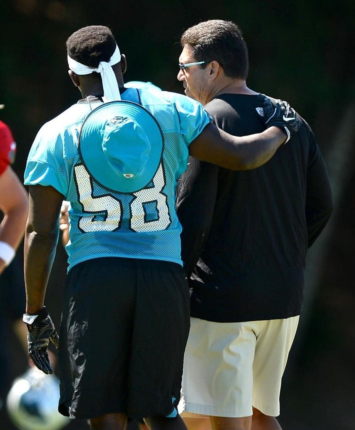 Carolina Panthers linebacker Thomas Davis, left, talks with head coach Ron Rivera during a training camp practice. Davis plays the same position that Rivera did during his own NFL career.