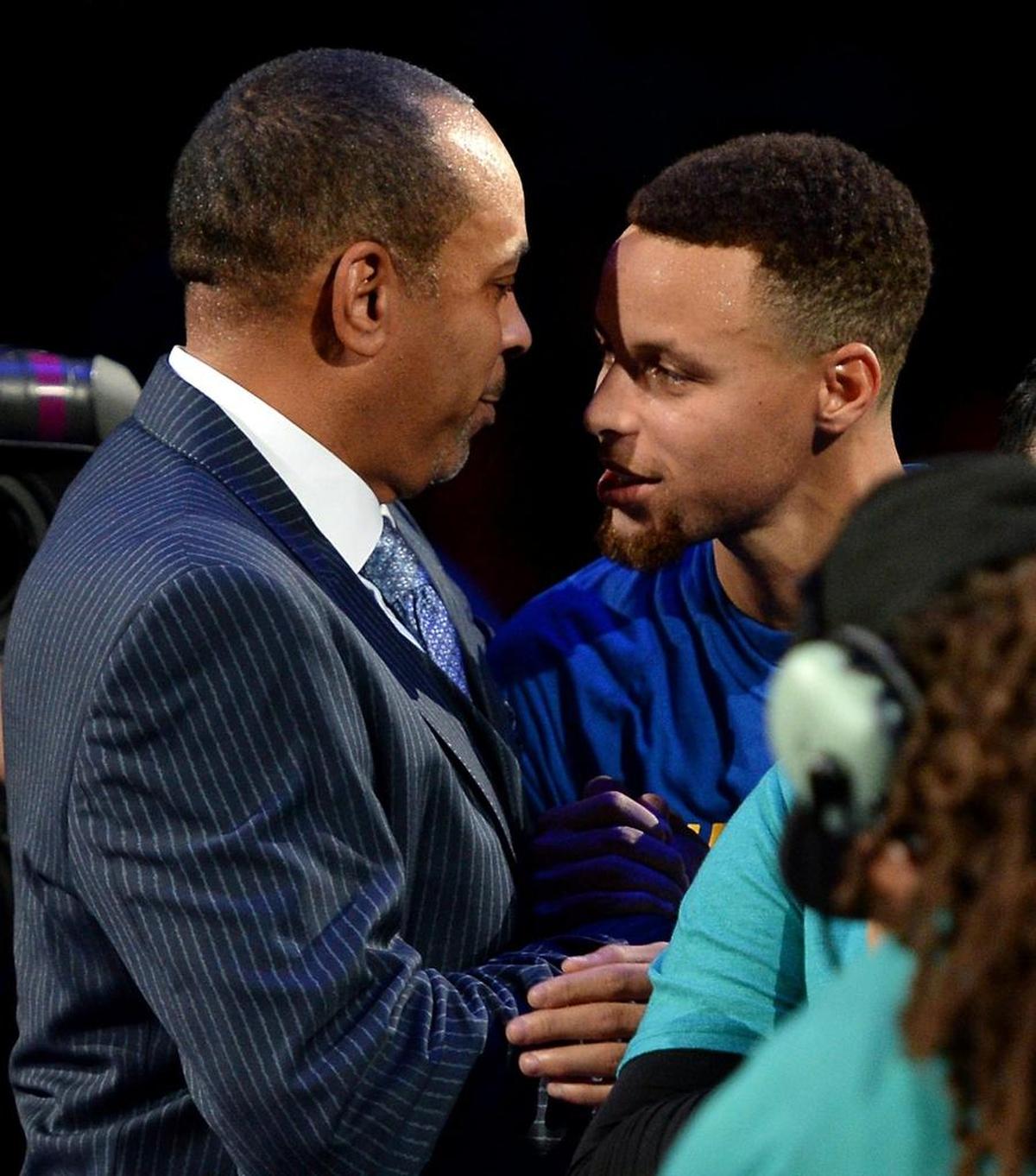Stephen Curry, here with his father, Dell, a Charlotte Hornets broadcaster, fell ill at Spectrum Center and could not play against the Hornets Saturday.