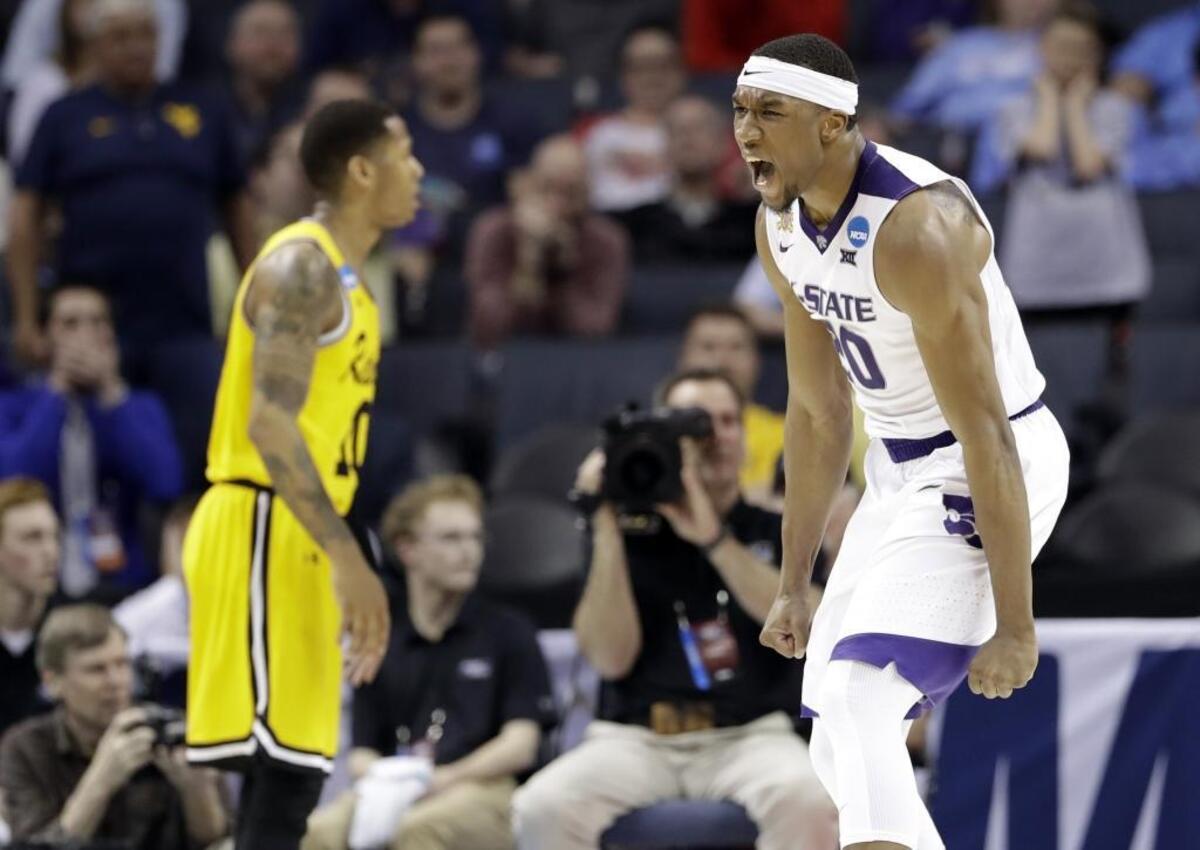 Kansas State's Xavier Sneed (20) celebrates after a dunk against UMBC during the second half of a second-round game in the NCAA men's college basketball tournament in Charlotte.