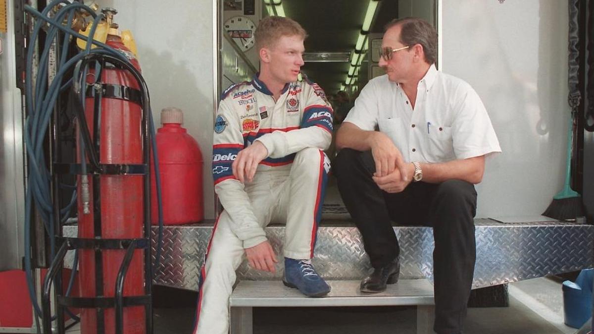 Dale Earnhardt Jr. and his father, Dale Earnhardt Sr., talk in Charlotte in 1998.