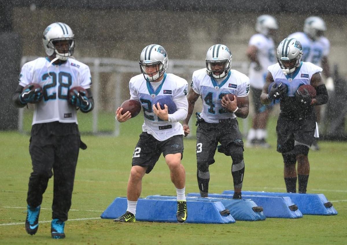 Carolina Panthers running backs Jonathan Stewart (28) and Christian McCaffrey, second from left, run through a drill during a rainy practice in September.