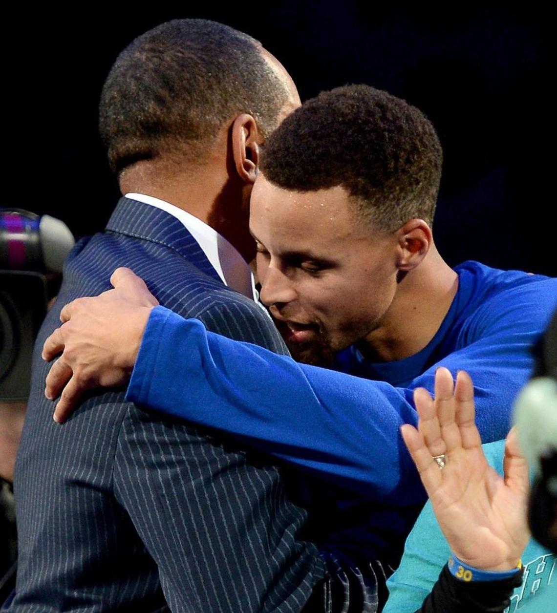 Golden State Warriors guard Stephen Curry, right, hugs his father, Dell Curry, following a ceremony recognizing the elder Curry's contributions to the Charlotte Hornets franchise in 2015.