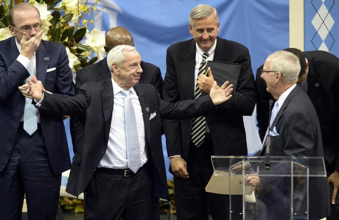 North Carolina basketball coach Roy Williams stretches his arms to hug Woody Durham in 2015 during a public memorial service for former basketball coach Dean Smith. Durham was the radio play-by-play announcer for the first NCAA championship teams for both Williams and Smith.