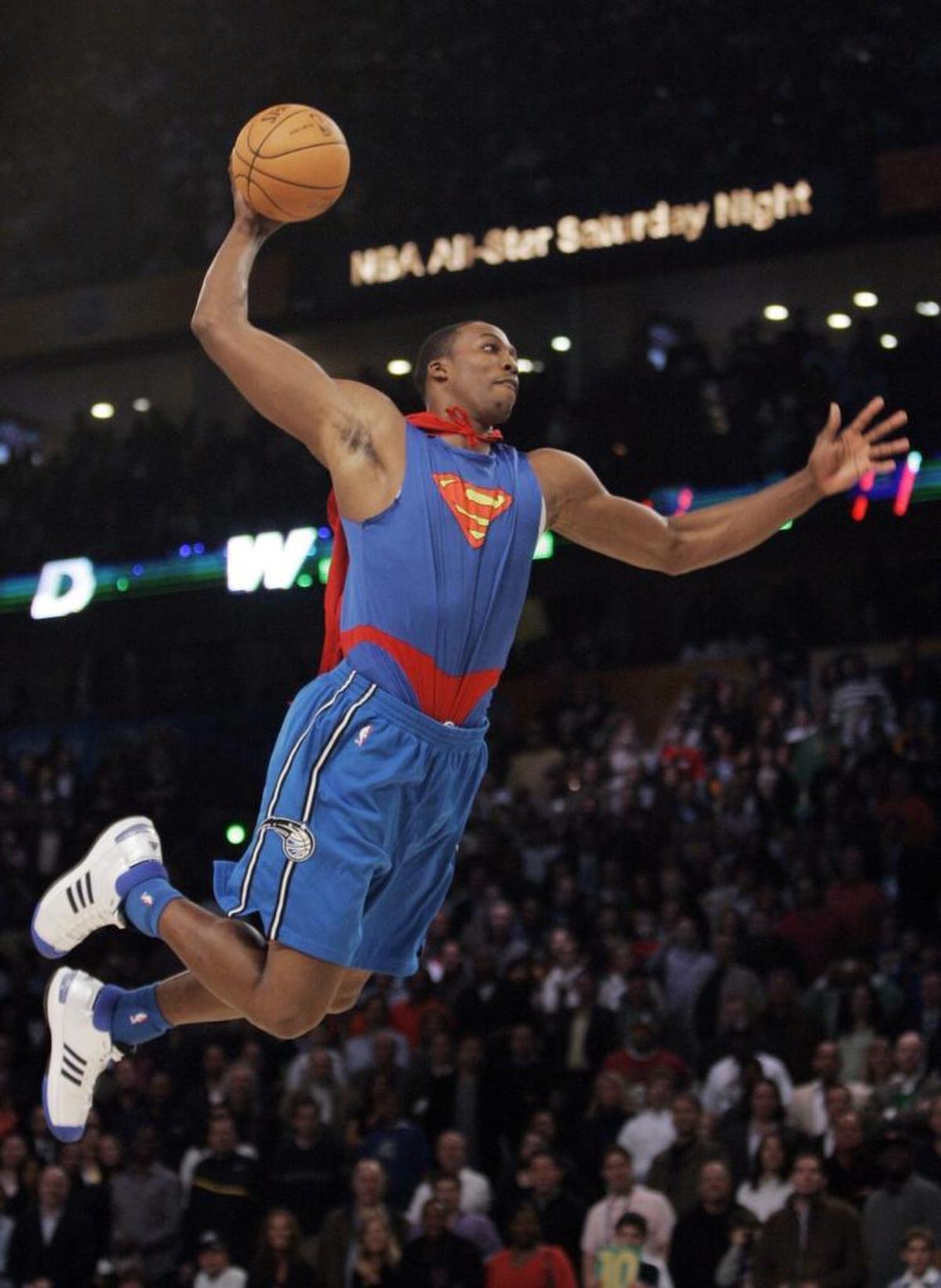 Wearing a Superman costume, including a cape, Orlando Magic's Dwight Howard flew toward the basket during the basketball slam dunk contest in 2008.