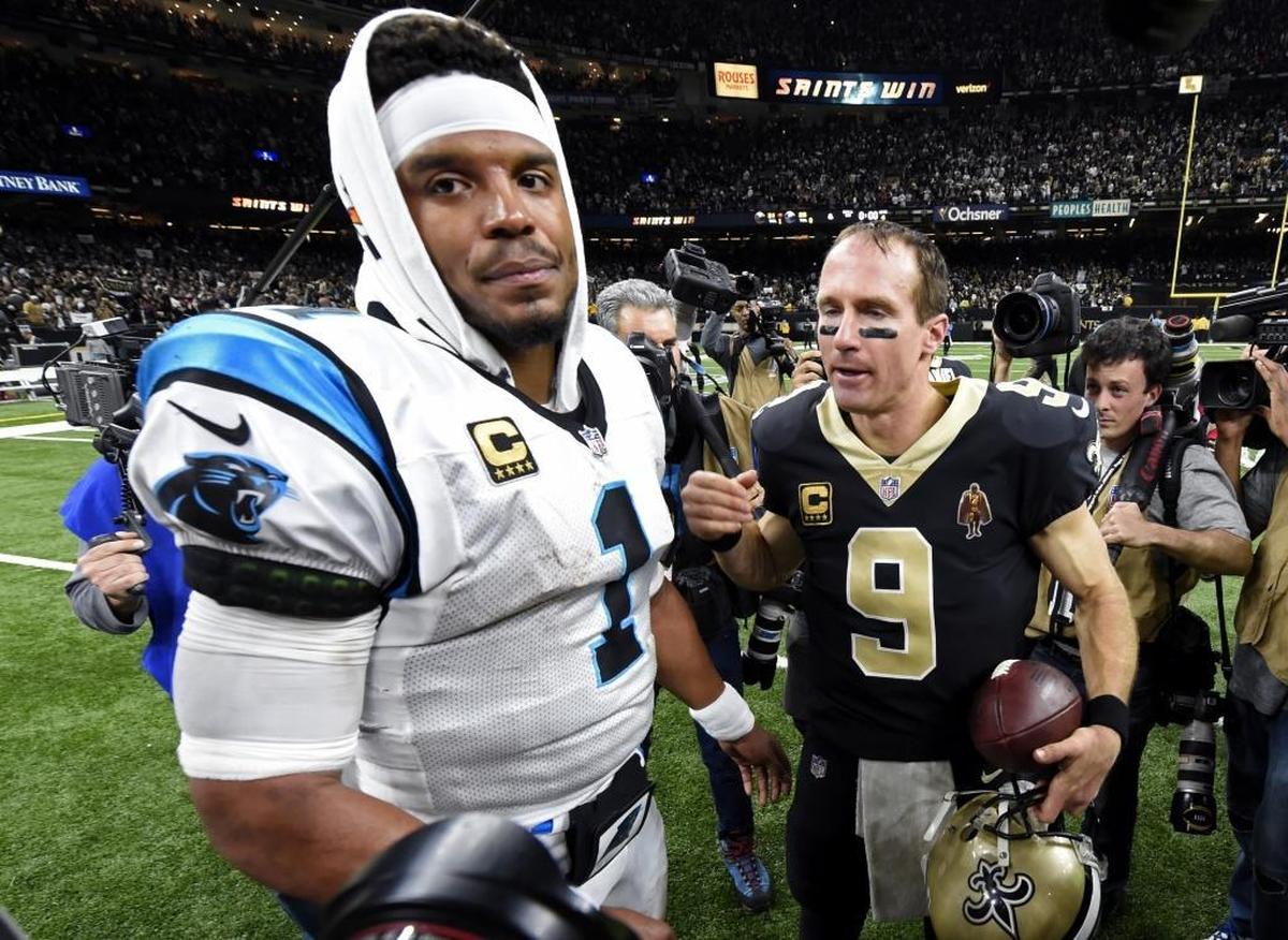 New Orleans Saints quarterback Drew Brees (9) greets Carolina Panthers quarterback Cam Newton (1) after the Saints’ 31-26 playoff win Sunday. Both quarterbacks threw for more than 340 yards.