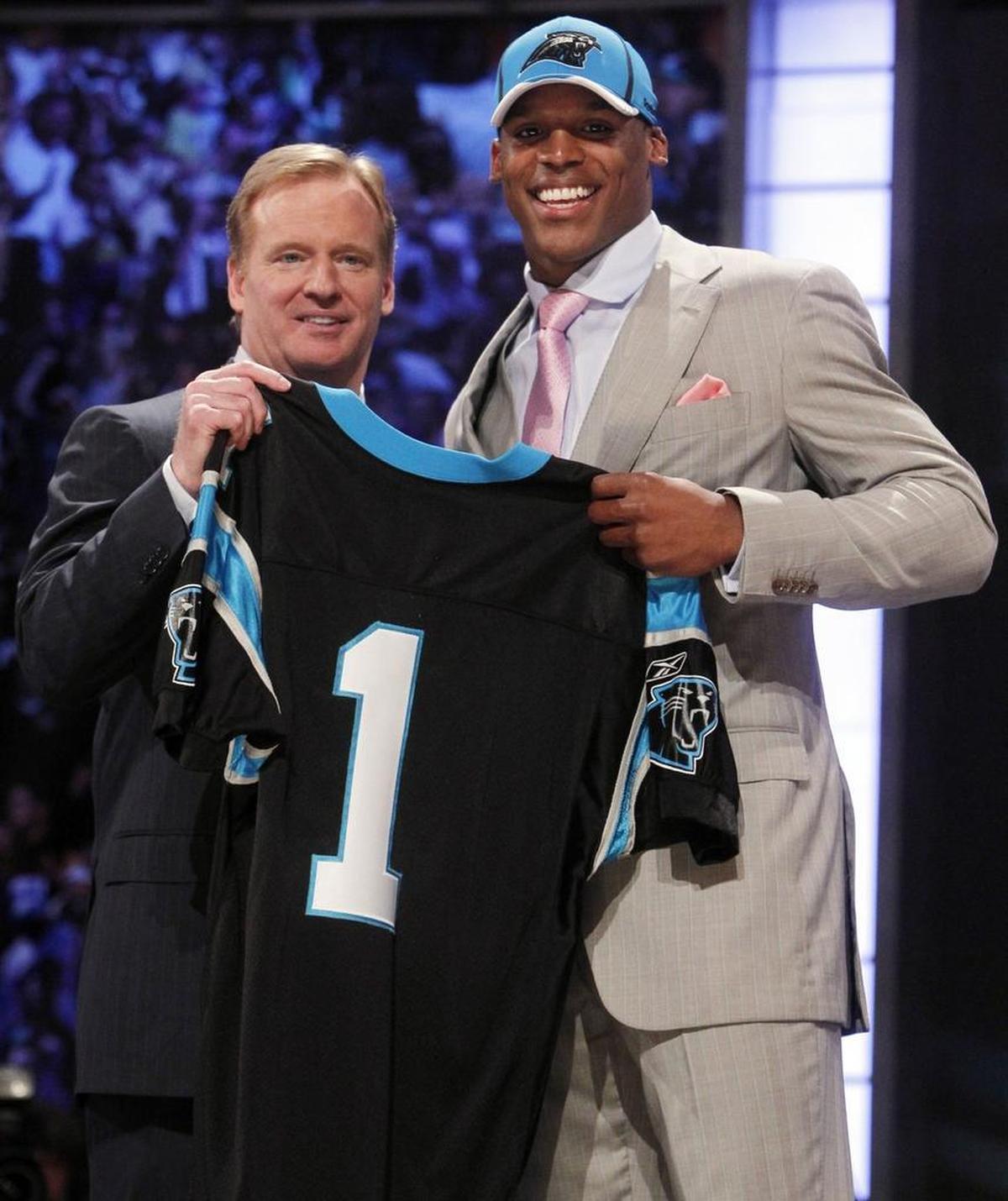 In 2011, Cam Newton (right) showed off the No. 1 jersey he would wear at Carolina after the Panthers picked him with the No. 1 overall draft choice. At left is NFL commissioner Roger Goodell.