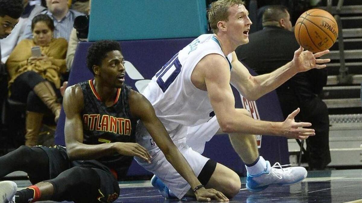 Charlotte Hornets center Cody Zeller, right, scrambles for a loose ball in the Hornets’ 107-84 win Wednesday night against Atlanta. Zeller led the Hornets with 19 points and 10 rebounds.