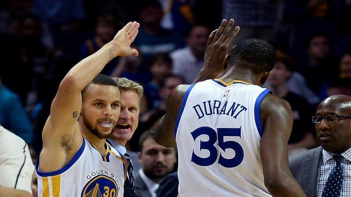 Golden State Warriors guard Stephen Curry, left, high-fives forward Kevin Durant during Wednesday’s game at the Spectrum Center. Durant led all scorers with 33 points and Curry finished with 28 as the Warriors defeated the Hornets, 113-103.