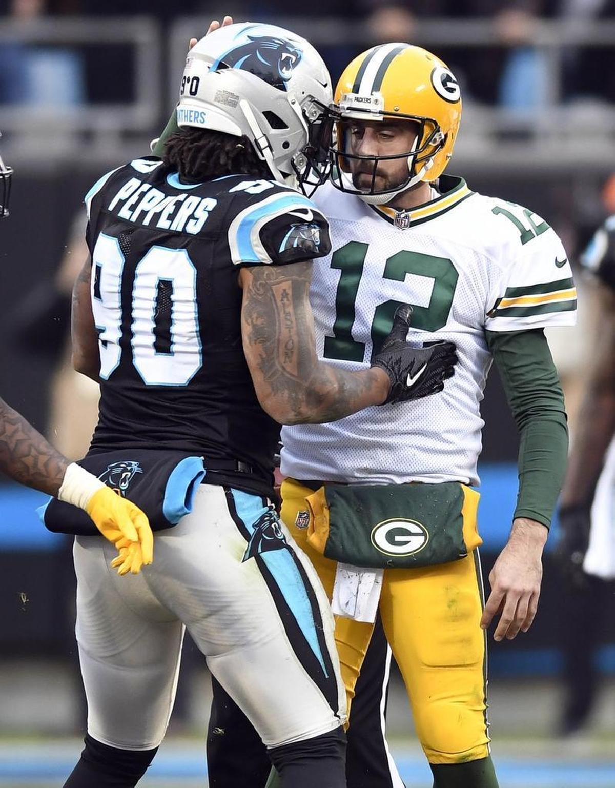 Carolina Panthers defensive end Julius Peppers (90) and Green Bay Packers quarterback Aaron Rodgers (12) – former teammates – chat right after a sack in the second half Sunday.
