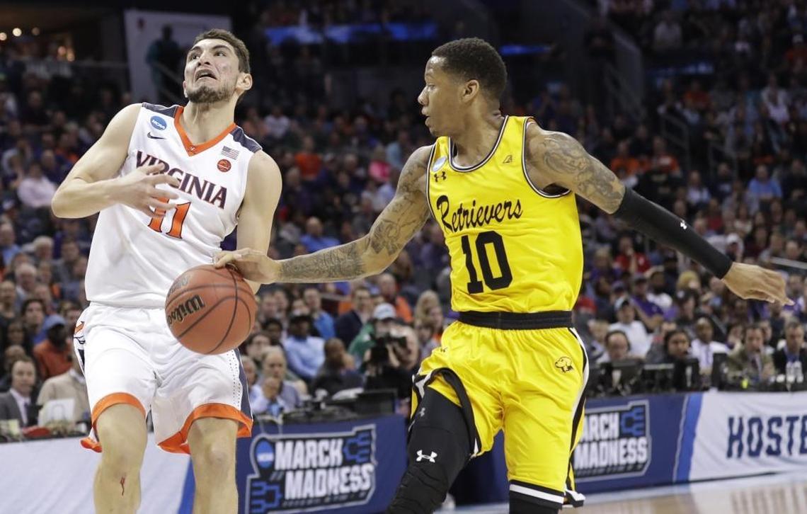 UMBC's Jairus Lyles (10) knocks the ball from Virginia's Ty Jerome (11) the first half of Friday’s first-round game in the NCAA men's college basketball tournament at Spectrum Center.