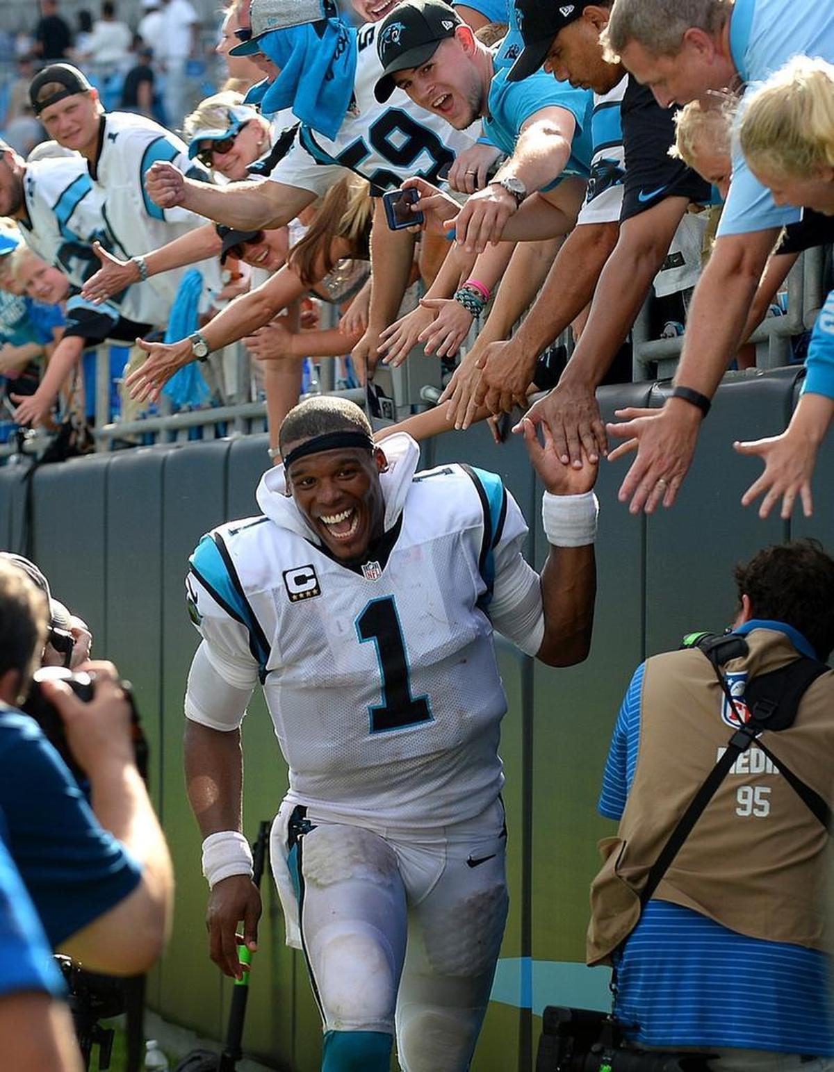 Carolina Panthers quarterback Cam Newton slaps hands with fans following a 2016 victory at Bank of America Stadium.