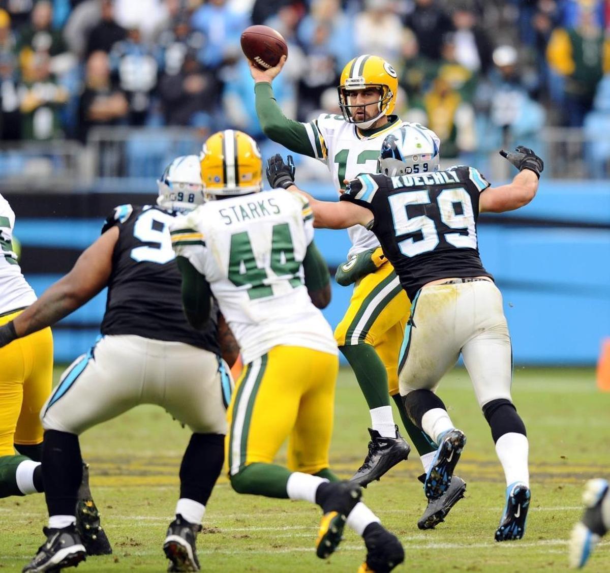 Green Bay’s Aaron Rodgers (12) throws a pass against Carolina in 2015 while under pressure from Carolina’s Luke Kuechly (59). The Panthers won that game, 37-29.