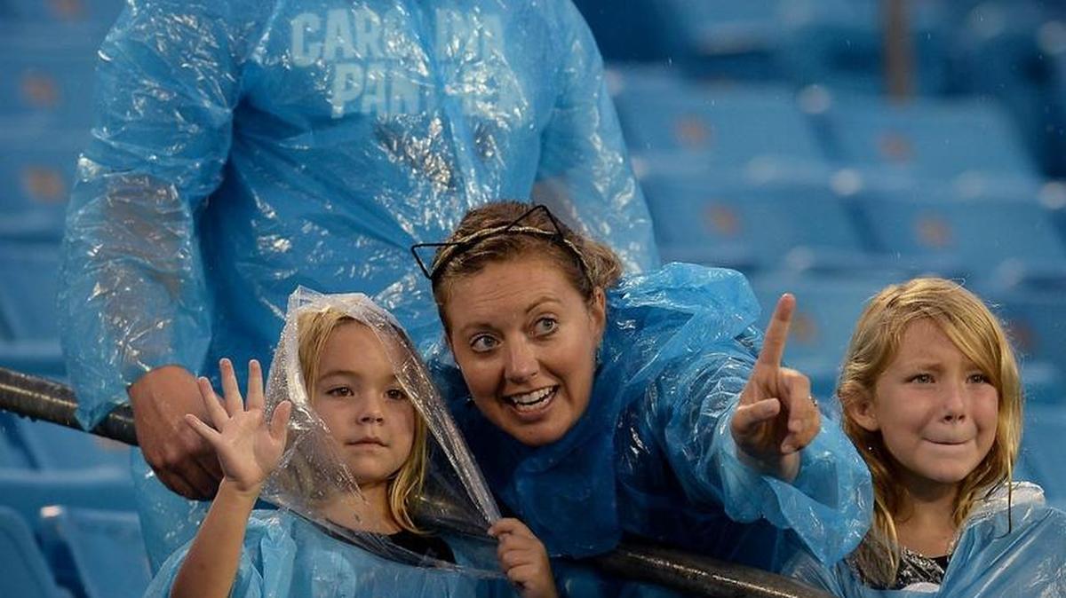 Carolina Panthers fans watch the players warm up in the rain Thursday at Bank of America Stadium. Kickoff for the exhibition against Pittsburgh was delayed because of lightning.