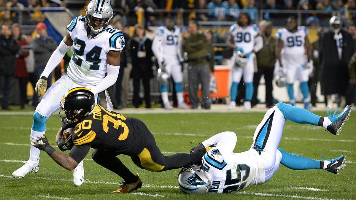 Carolina Panthers safety Eric Reid, right, and cornerback James Bradberry, left, try to slow down Pittsburgh Steelers running back James Conner during Thursday’s NFL game in Pittsburgh. The Steelers won 52-21.