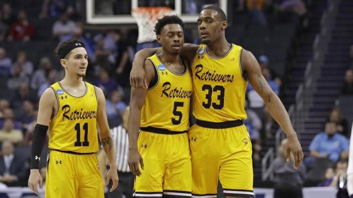 UMBC's Arkel Lamar, Jourdan Grant and K.J. Maura, from right, embrace as they leave the court in the closing moments of the team's 50-43 loss to Kansas State in an NCAA second-round game Sunday.
