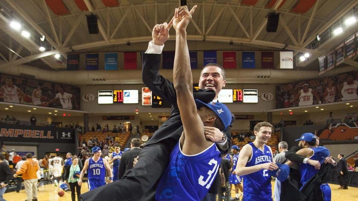 UNC Asheville’s Sam Hughes (31) lifts coach Nick McDevitt into the air after the Bulldogs clinched an NCAA tournament bid by winning the Big South championship over Winthrop in Buies Creek, N.C. on Sunday, March 6, 2016. UNC Asheville faces Villanova in a first-round NCAA tournament game Friday.