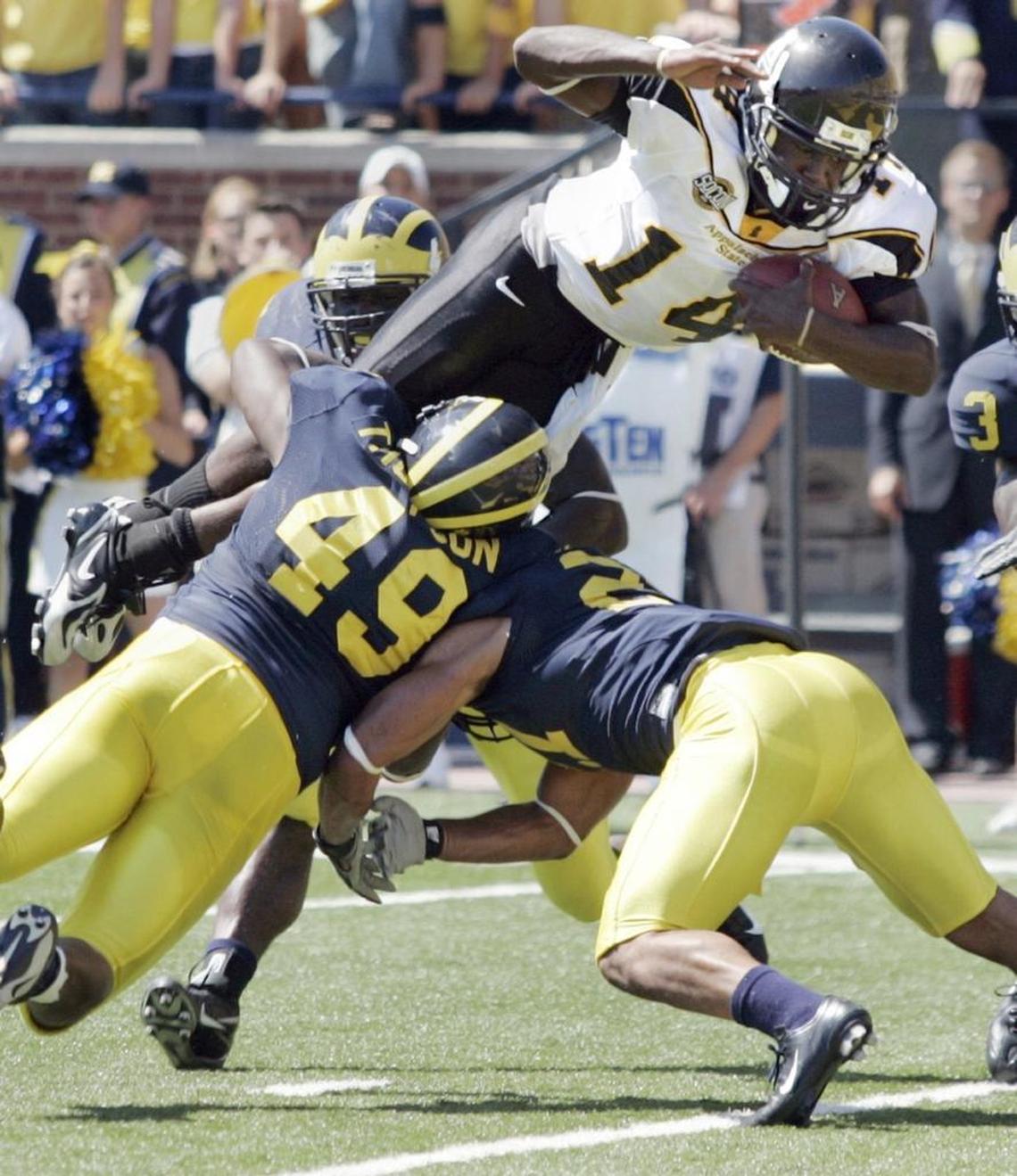 Appalachian State quarterback Armanti Edwards dives over two Michigan tacklers for a touchdown. Edwards threw for three scores and ran for another in Appalachian State’s 34-32 upset.