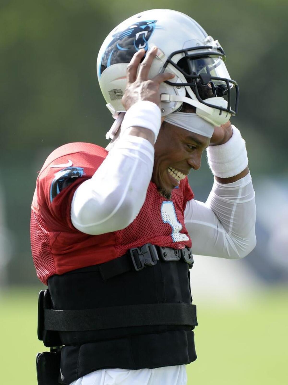 Carolina Panthers quarterback Cam Newton pulls his helmet off after a drill in Tennessee on Aug. 17th.