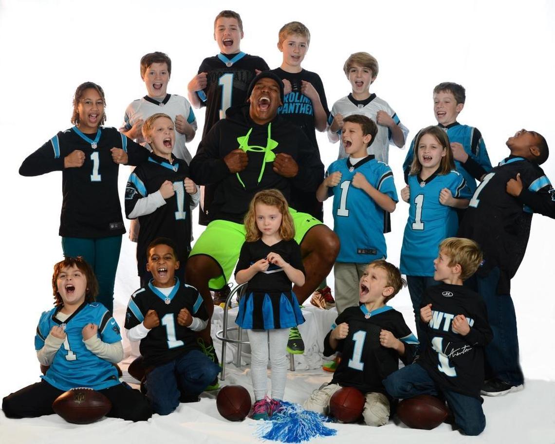 Panthers quarterback Cam Newton (center) did a Superman pose for The Charlotte Observer in 2013 along with some of the children that he had given a “touchdown ball” to during his career.