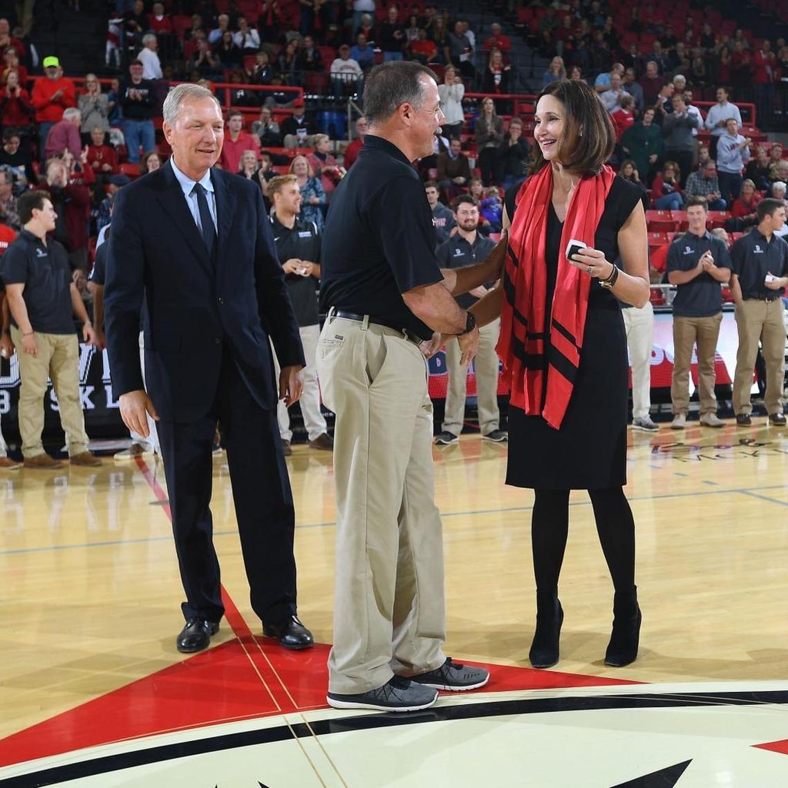 Davidson baseball head coach Dick Cooke (center) receives his NCAA Tournament ring from Davidson president Carol Quillen (right) and athletic director Jim Murphy in November.
