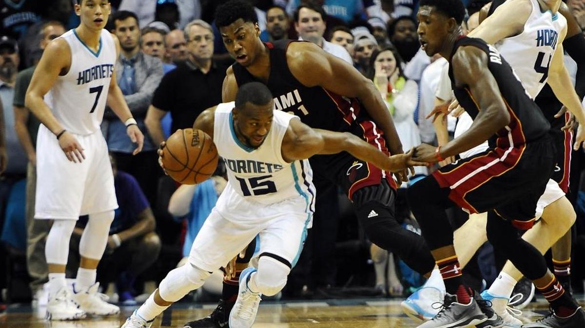 Charlotte Hornets guard Kemba Walker (15) dribbles away from Miami Heat center Hassan Whiteside (21) and guard Josh Richardson (0) during the second half in Game 4 of the Eastern Conference playoffs' first round on Monday, April 25, 2016. The Hornets won 89-85, evening the series at 2-2.